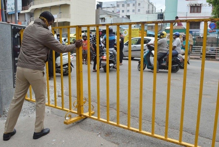  A policeman removes the barricades of a road as the Karnataka State government eased the COVID-19 restrictions in Bangalore, India, on June 14, 2021. The Karnataka State government has eased restrictions for essential services. (Str: Xinhua)
