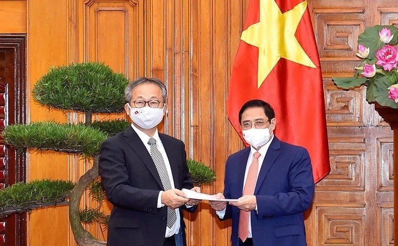 The Japanese Ambassador conveys a message from the Japanese Prime Minister Suga Yoshihide to PM Pham Minh Chinh, which announced the Japanese Government’s decision to provide Vietnam with 1 million doses of the COVID-19 vaccine. (Photo: VGP)