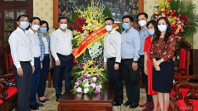 Politburo member Dinh Tien Dung (fourth from left) and other leaders of Hanoi present a flower bucket to congratulate Nhan Dan Newspaper. (Photo: NDO)