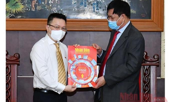 Nhan Dan Newspaper's Editor-in-chief Le Quoc Minh present the special edition on Revolutionary Press Day to Secretary of the Party Committee of the Central Agencies' Bloc Huynh Tan Viet (right). (Photo: NDO)