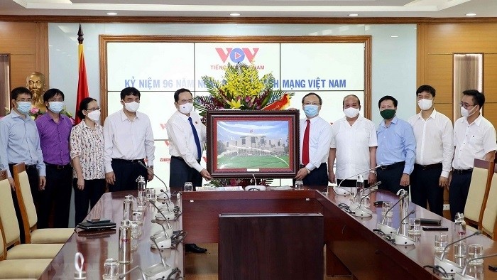 Standing Vice Chairman of the National Assembly Tran Thanh Man (L) presents a photo of the National Assembly House to the Voice of Vietnam on the 96th anniversary of Vietnam Revolutionary Press Day. (Photo: VNA)