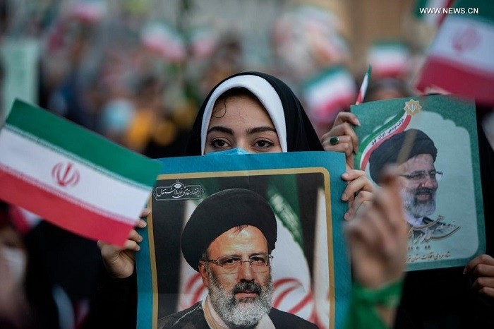 A woman holds a poster as supporters celebrate after Ebrahim Raisi won the presidential election in Tehran, Iran, on June 19, 2021. Judiciary Chief Ebrahim Raisi won Iran's presidential race by securing over 60 percent of votes, the Iranian Interior Ministry announced on Saturday. (Photo: Xinhua)