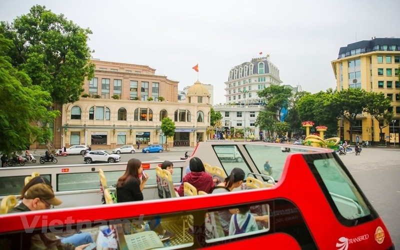 An open top double-decker bus carries tourists to famous destinations in Hanoi (Photo: Vietnamplus.vn)