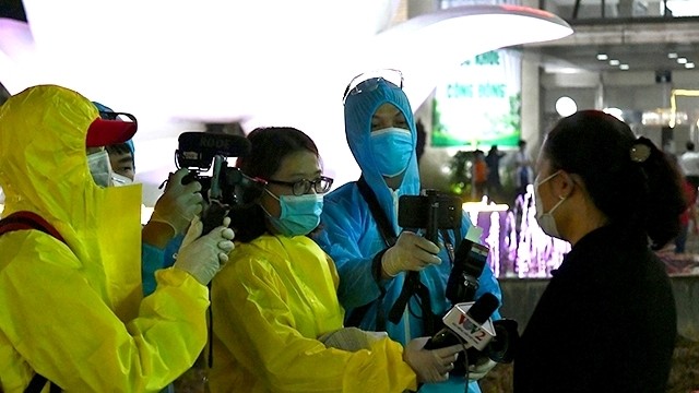 Reporters working at the quarantine areas in Bach Mai Hospital in Hanoi. (Photo: NDO/Dang Anh)