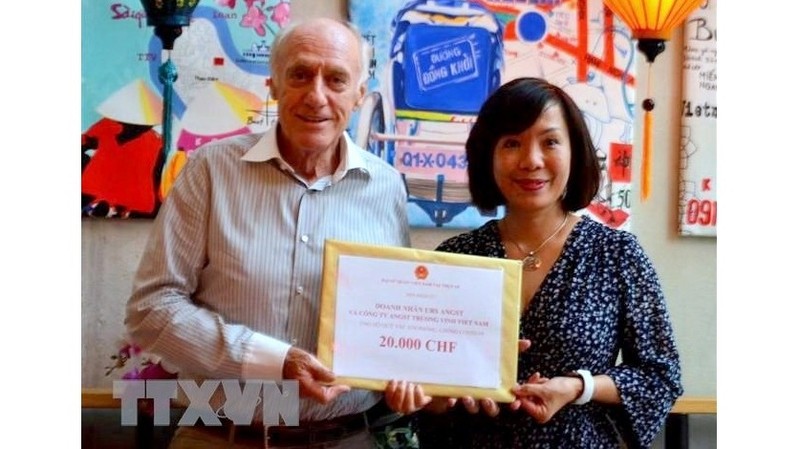 Vietnamese Ambassador Le Linh Lan (R) receives the donation from Swiss businessman Urs Angst. (Photo: VNA)