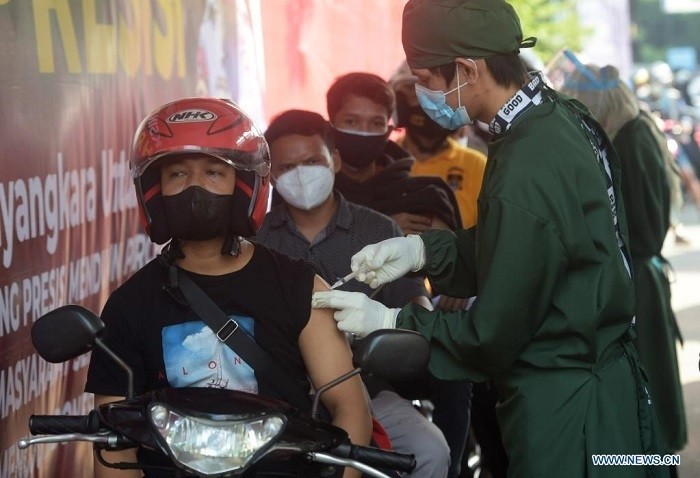 A man riding his motorbike receives a dose of COVID-19 vaccine at a drive-through vaccination site in Jakarta, Indonesia, July 2, 2021. Indonesia's Health Ministry on July 1 launched the mass COVID-19 vaccination for children of 12 to 17 years old as the national capital held its first mass inoculation for adolescents. (Photo: Xinhua)