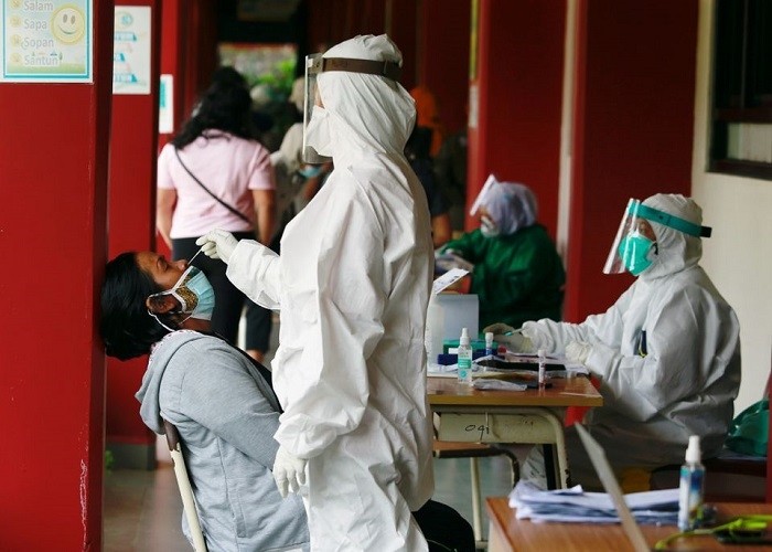 A healthcare worker in personal protective equipment takes a swab sample from a person to test for the coronavirus disease (COVID-19) during mass testing at a school in Jakarta, Indonesia, July 2, 2021. (Photo: Reuters)