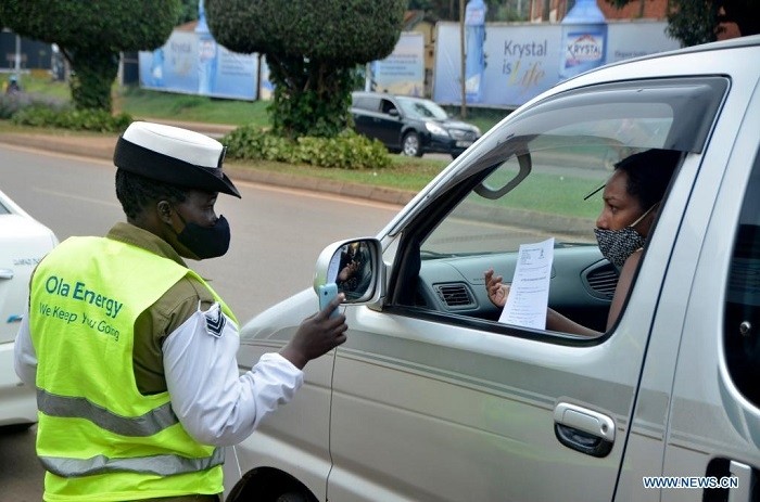 A police officer wearing a face mask talks to a woman in a vehicle in Kampala, Uganda, on July 4, 2021. Uganda has introduced new penalties for offenders of the country's COVID-19 prevention procedures. (Photo: Xinhua)