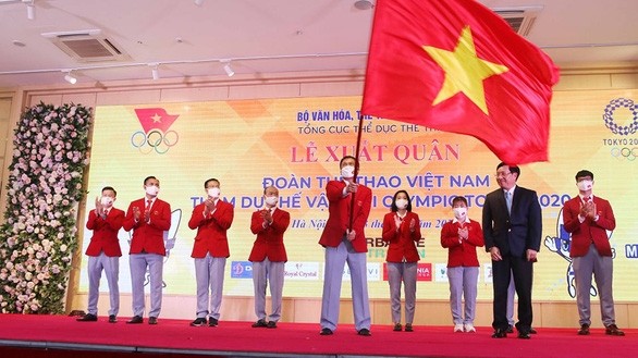 Deputy Prime Minister Pham Binh Minh hands over the national flag to the head of the Vietnamese Olympic contingent Tran Duc Phan. 