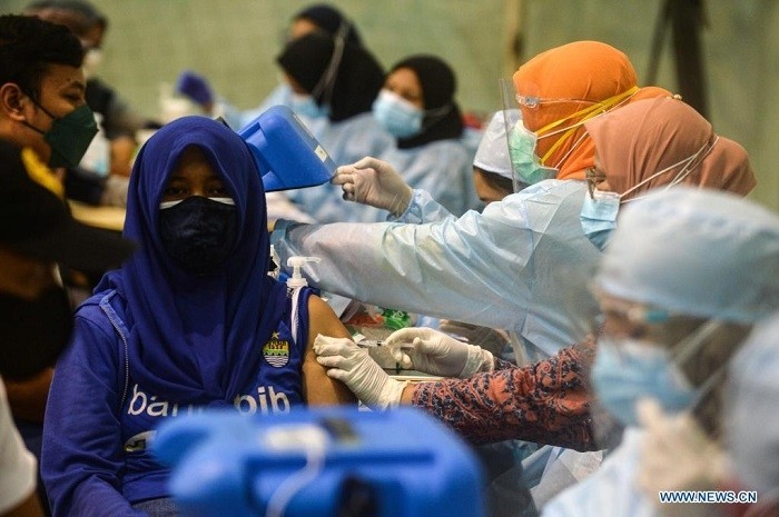 A woman receives a dose of COVID-19 vaccine during a mass vaccination campaign at Ciledug Youth Sport Center in Tangerang, Indonesia, July 17, 2021. (Photo: Xinhua)
