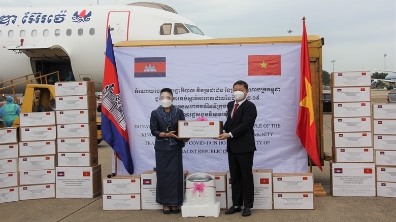 Youk Sambath, Secretary of State under the Cambodian Ministry of Health (left) hands over the aid to Vice Chairman of HCM City People’s Committee Duong Anh Duc.