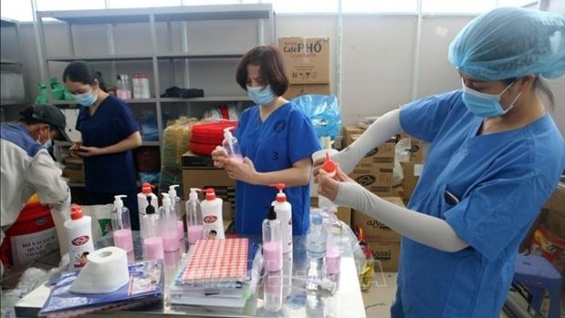 Health workers preparing bottles of hand sanitiser for for patient rooms at a COVID-treatment hospital in Da Nang (Photo: VNA)