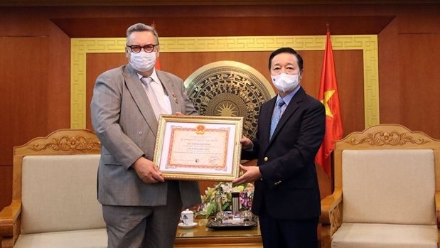 Minister of Natural Resources and Environment Tran Hong Ha presents the "For the Cause of Natural Resources and Environment" insignia to Finnish Ambassador to Vietnam Kari Kahiluoto. (Photo: baotainguyenmoitruong.vn)