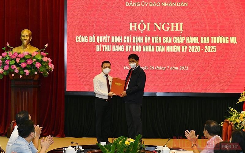 Member of the Party Central Committee and Secretary of the Party Committee of the Central Agencies’ Bloc Huynh Tan Viet (R) hands over the decision of the Standing Board of the Party Committee of the Central Agencies’ Bloc to new Secretary of the Party Committee of Nhan Dan Newspaper Le Quoc Minh.
