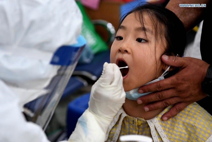 A medical worker takes a swab sample from a child for COVID-19 nucleic acid testing in Erqi District of Zhengzhou, central China's Henan Province, Aug. 1, 2021. (Photo: Xinhua)
