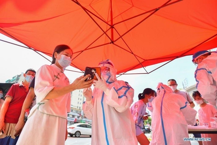 A health worker verifiies ID information of a citizen at a COVID-19 nucleic testing site in Nandaqiao community, Chiling Road sub-district, Tianxin District of Changsha, capital of central China's Hunan Province, July 31, 2021. Local COVID-19 prevention and control authority in Changsha announced Saturday that three areas in the city have heightened their risk for COVID-19 infection from low to medium, and all-inclusive nucleic testing is now under way in these areas. (Photo: Xinhua)