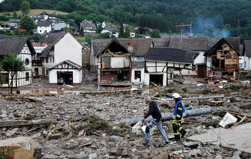 A man and firefighter walk through debris, following heavy rainfall in Schuld, Germany, July 15, 2021. (Photo: Reuters)