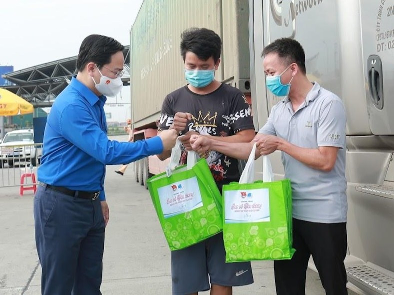 First Secretary of the HCYU Central Committee Nguyen Anh Tuan presents gifts to long-distance drivers at Phap Van - Cau Gie checkpoint. (Credit: Bao Anh)