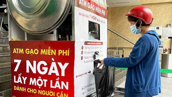 A woman collects rice from the ‘rice ATM’ machine in Ho Chi Minh City.