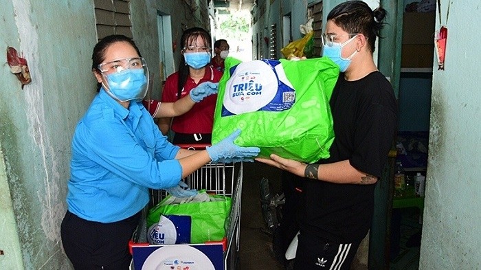 Members of the Vietnam Youth Federation present rice and food to needy people in Ho Chi Minh City.