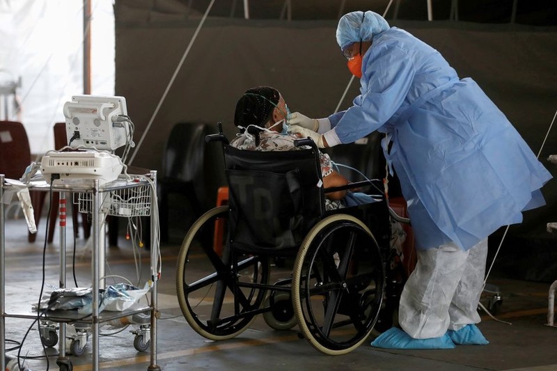 A healthcare worker tends to a patient at a temporary ward set up during the coronavirus disease (COVID-19) outbreak, at Steve Biko Academic Hospital in Pretoria, South Africa, January 19, 2021. (Photo: Reuters)