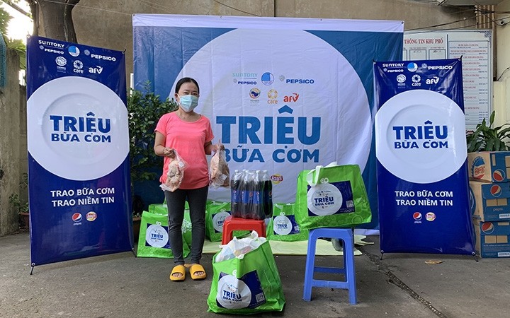 A woman in Ho Chi Minh City receives an aid package from AFV and CARE International in Vietnam. (Photo: AAV)