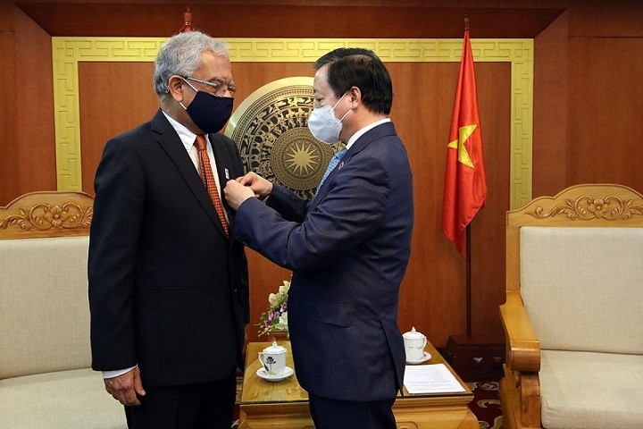 Minister of Natural Resources and Environment Tran Hong Ha presents the “For the Cause of Natural Resources and Environment” insignia to UN Resident Coordinator in Vietnam Kamal Malhotra. (Photo: baotainguyenmoitruong.vn)