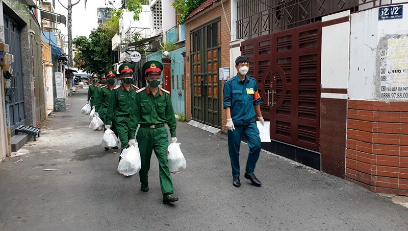 Soldiers go to the market and bring necessities to locals in District 10 in Ho Chi Minh City. (Photo: Phuoc Thien)