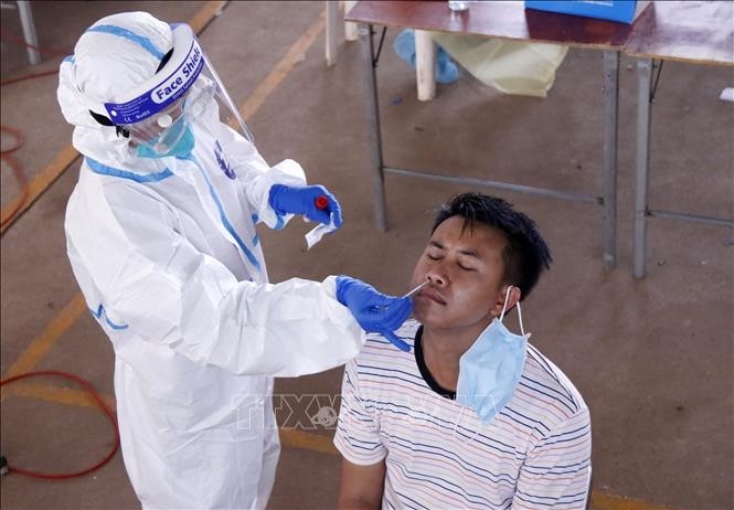 A medical worker is taking samples for COVID-19 testing in Vientiane, Laos. (Photo: VNA) 