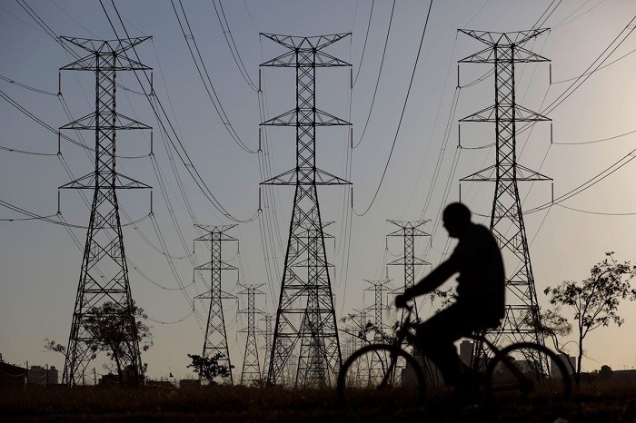 A man rides a bicycle near power lines connecting pylons of high-tension electricity, in Brasilia, Brazil August 31, 2017. (Photo: Reuters)