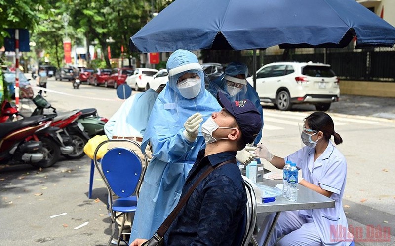 A medical worker in Hanoi takes swab samples from a man for COVID-19 testing. (Photo: NDO/Duy Linh)