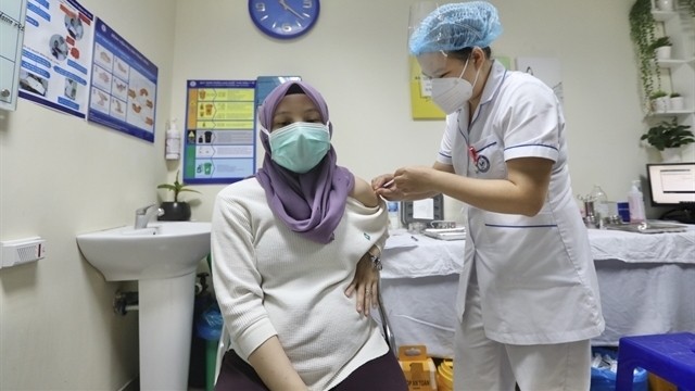 A pregnant staff member at the Malaysian embassy receives a COVID-19 vaccine shot at the National Hospital of Obstetrics and Gynecology in Hanoi. (Photo: VNA)