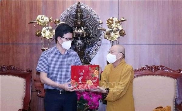 Vice Chairman of the Government Committee for Religious Affairs Nguyen Tien Trong (L) presents gifts Most Venerable Thich Thien Duc, deputy head of the Executive Board of the VBS chapter in HCM City (Photo: VNA)