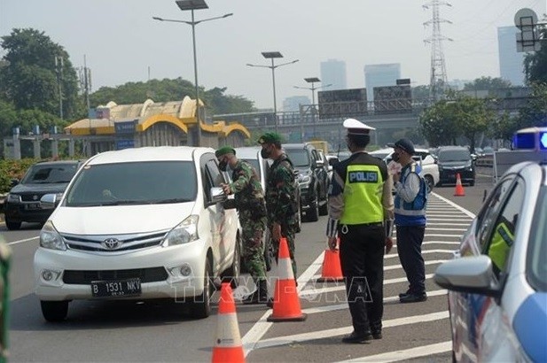 Police monitor travel on a road in Indonesia. (Photo: Xinhua/VNA)