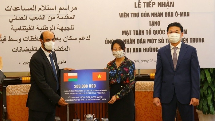 Omani Ambassador to Vietnam Saleh Mohamed Ahmed Al Suqri (L) presents symbolic support of US$300,000 to a representative from the Vietnam Fatherland Front Central Committee.