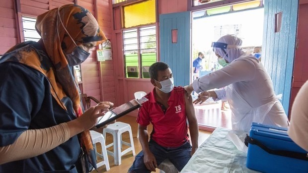 A man gets a shot of COVID-19 vaccine in Selangor state of Malaysia (Photo: Xinhua/VNA)