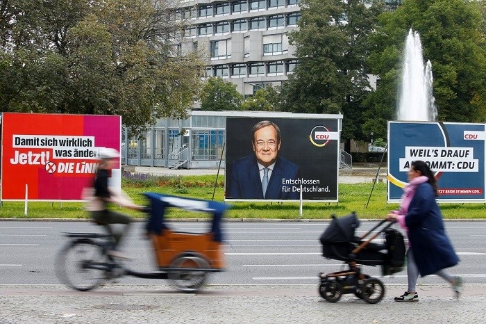 People pass by election campaign billboards featuring Christian Democratic Union (CDU) party leader and top candidate for chancellor, Armin Laschet, and the left wing party Die Linke, in Berlin, Germany, September 20, 2021. (Photo: Reuters) 