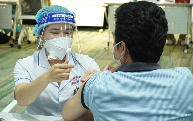 A medical worker gives COVID-19 vaccine shot to a man in Ho Chi Minh City. (Photo: VNA)