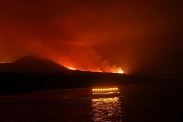 Coastguards pass as lava is seen arriving at the sea following the eruption of a volcano, seen from the Port of Tazacorte, on the Canary Island of La Palma, Spain, September 28, 2021. (Photo: Reuters)