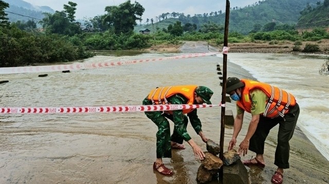 Border guards in Huong Lap Border Station in the central province of Quang Tri set up warning signs in areas flooded due to increasing water levels in Huong Lap Commune. (Photo: VNA)