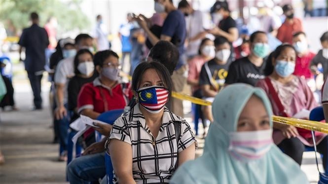 People wait to receive COVID-19 vaccines in Klang of Selongor, Malaysia  (Photo: THX/VNA)