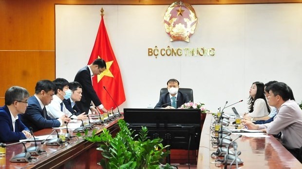 Deputy Minister of Industry and Trade Do Thang Hai (centre) and other officials at the teleconference on October 14 (Photo: VNA)
