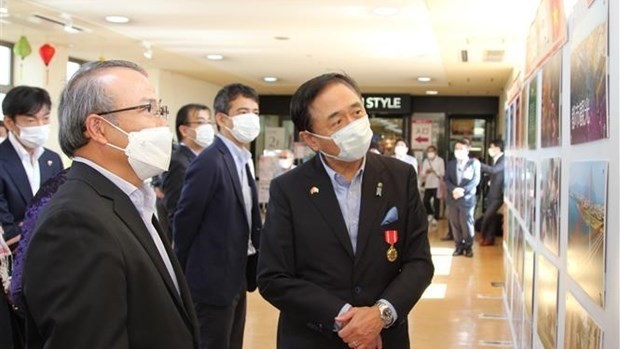 Kanagawa's Governor Kuroiwa Yuji and Vietnamese Ambassador to Japan Vu Hong Nam (L) look at photos displayed at the event. (Photo: VNA)