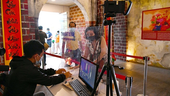 Visitors check their body temperature and make a medical declaration before visiting the Thang Long Imperial Citadel. Photo: MINH HA