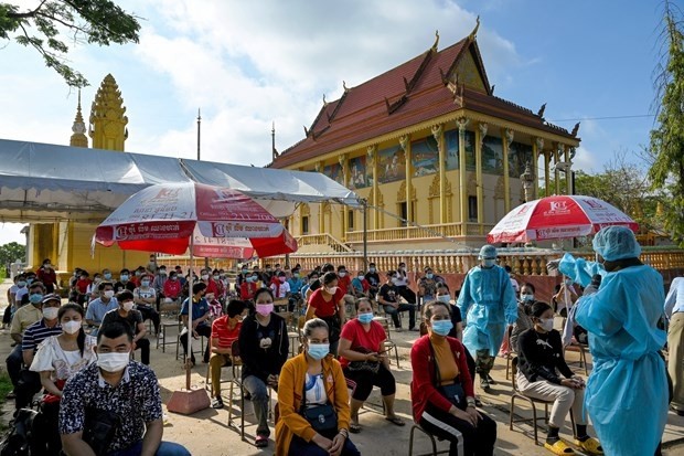  People wait to receive COVID-19 vaccine at a pagoda in Phnom Penh, Cambodia. (Photo: AFP/VNA)