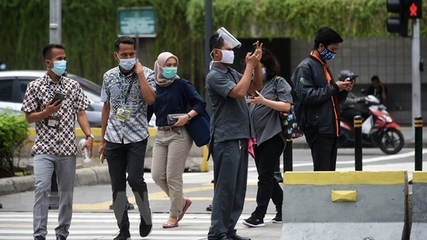 People wear face masks to avoid COVID-19 infection in Jakarta, Indonesia. (Photo: Xinhua/VNA)