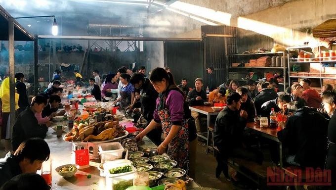 The food area is the highlight of the Meo Vac market with hundreds of packed stalls, attracting a large number of people. Steam and kitchen smoke rise and mingle with the early morning sunlight, creating a cosy feeling.
