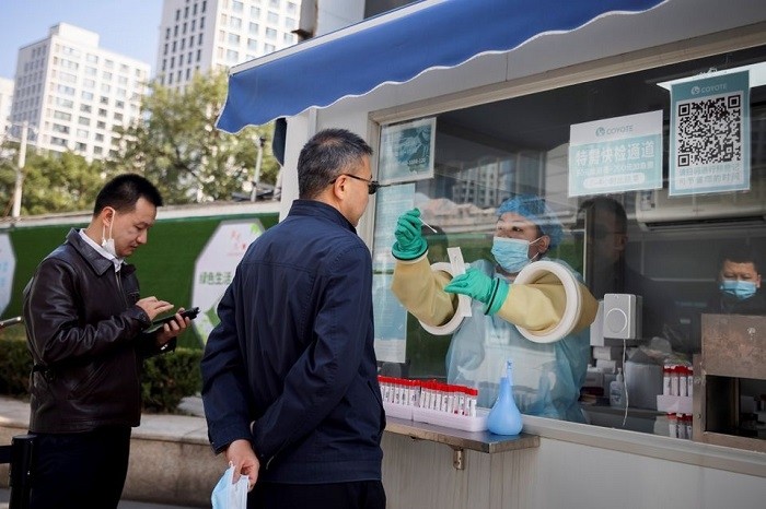 A medical staff administers a nucleic acid test at a booth on a street in Beijing, China, as outbreaks of the coronavirus disease (COVID-19) continue, October 20, 2021. (Photo: Reuters)