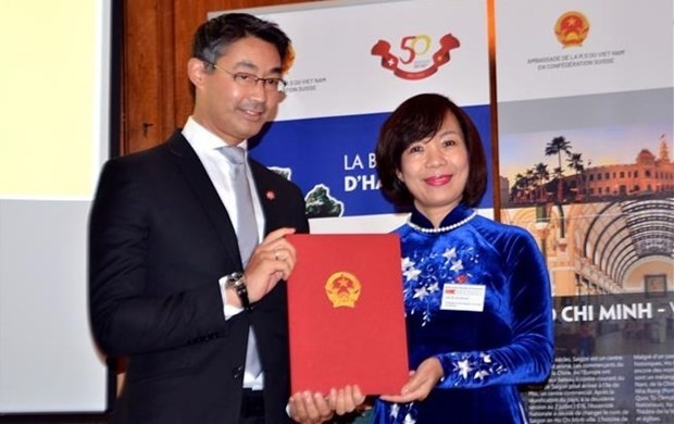 Vietnamese Ambassador to Switzerland Le Linh Lan presents the decision to Dr. Philipp Rosler. (Photo: VNA)