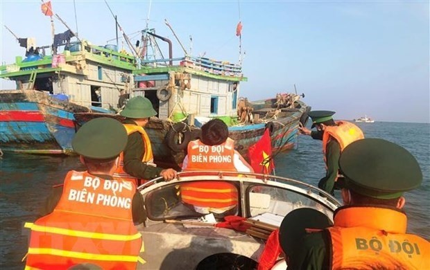 Border guards in Quang Binh province examine a fishing boat and disseminate legal regulations to fishermen. (Photo: VNA)